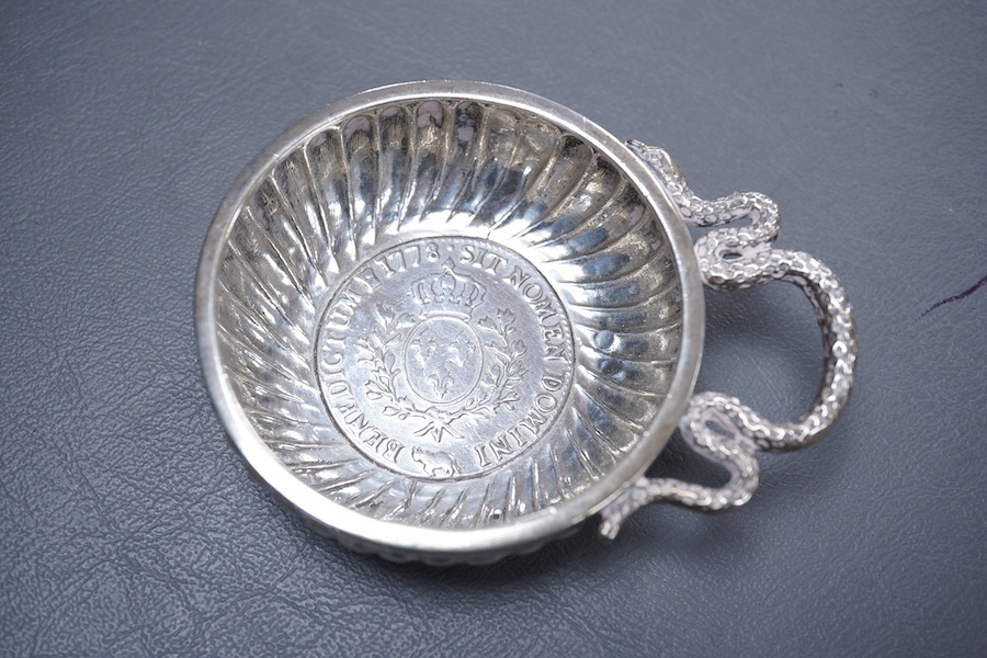 A late 18th century French white metal taste vin, with serpent handle and inset coin base, cockerel mark, 93mm, 96 grams.